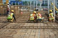 Construction workers fabricating floor slab reinforcement bar